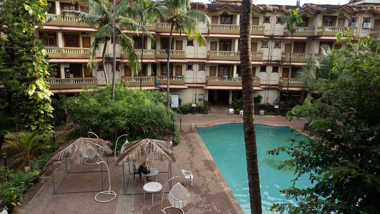 Facade of Vistar Holidays, Goa with a swimming pool in front.