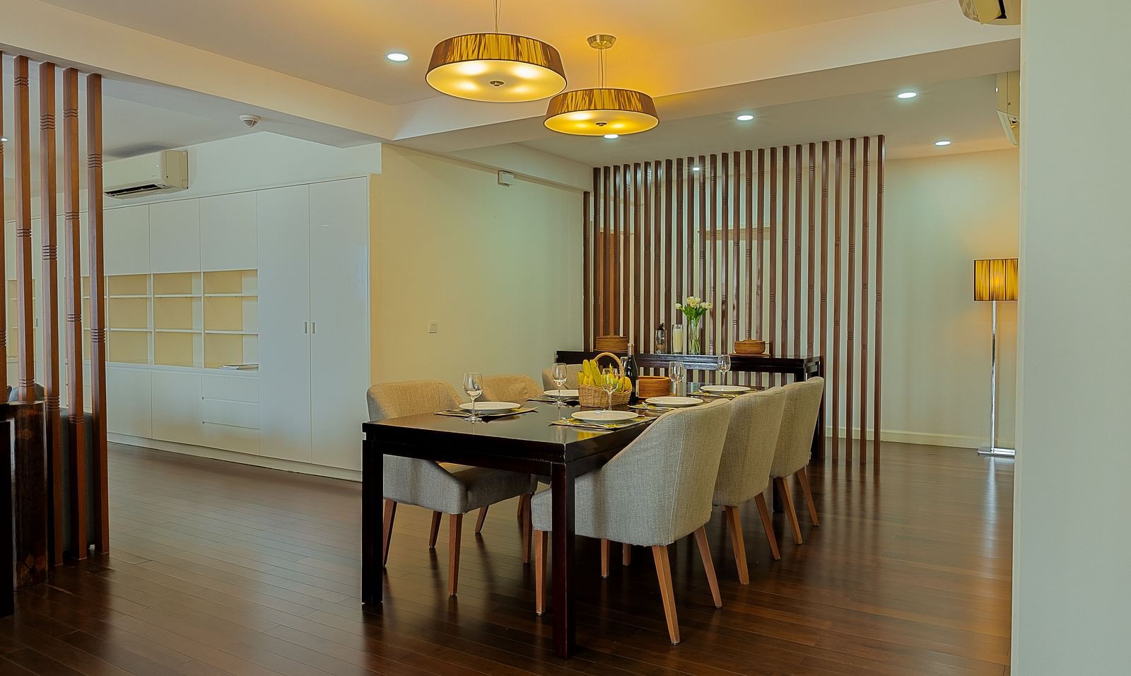 A dining area with a wooden table, chairs, and a chandelier overhead | Penthouse | Central Mansions, Phnom Penh