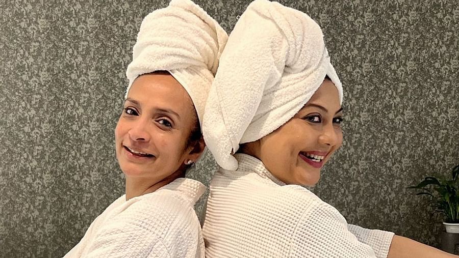 two indian women celebrities posing for a picture while wearing a robe - IOSIS Spa & Wellness