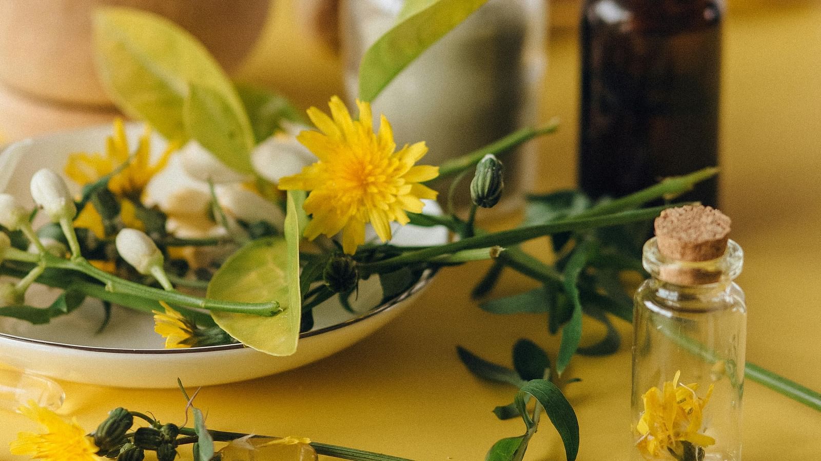 Image of essential oil and flowers kept on the table.