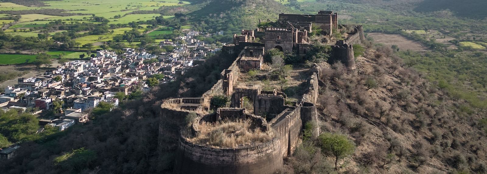 An aerial image of a fort with the backdrop of mountains