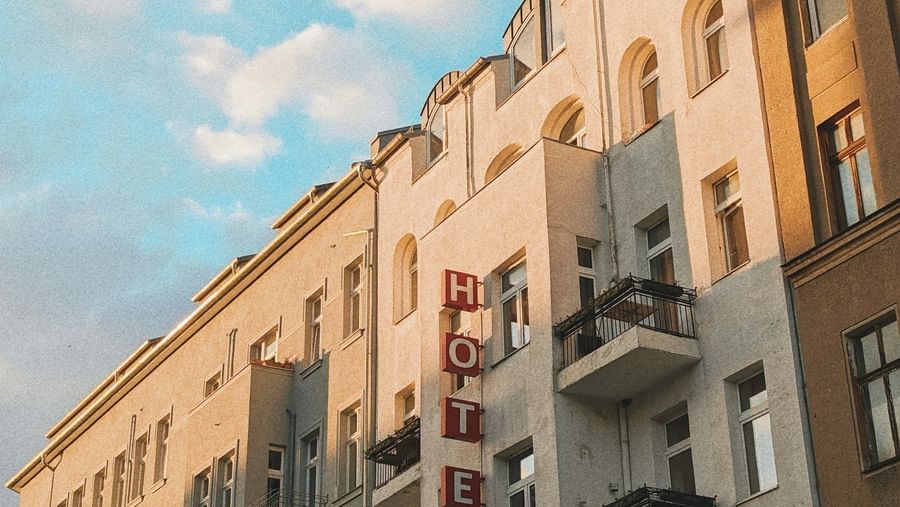  A low-angle view of a row of European-style buildings with balconies under a blue sky