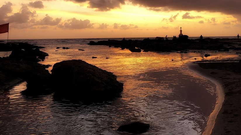 The golden hue of the sunset reflects on the water at Morjim Beach - Best Places to Visit in Morjim