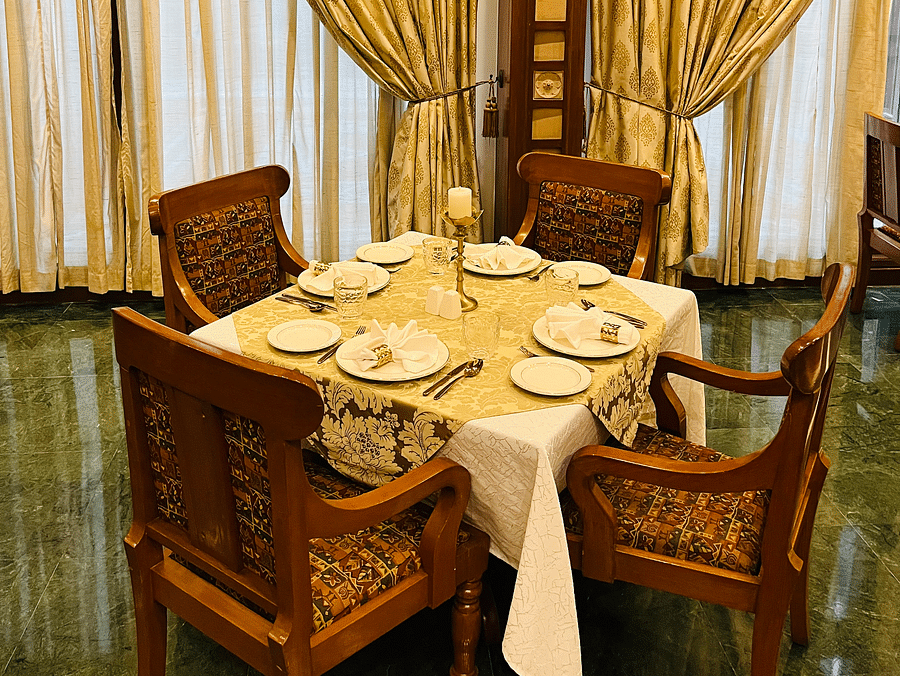 Close-up of a dining table set in a royal ambience at Kesar Restaurant, The Ummed Ahmedabad, showcasing elegant tableware and sophisticated decor.