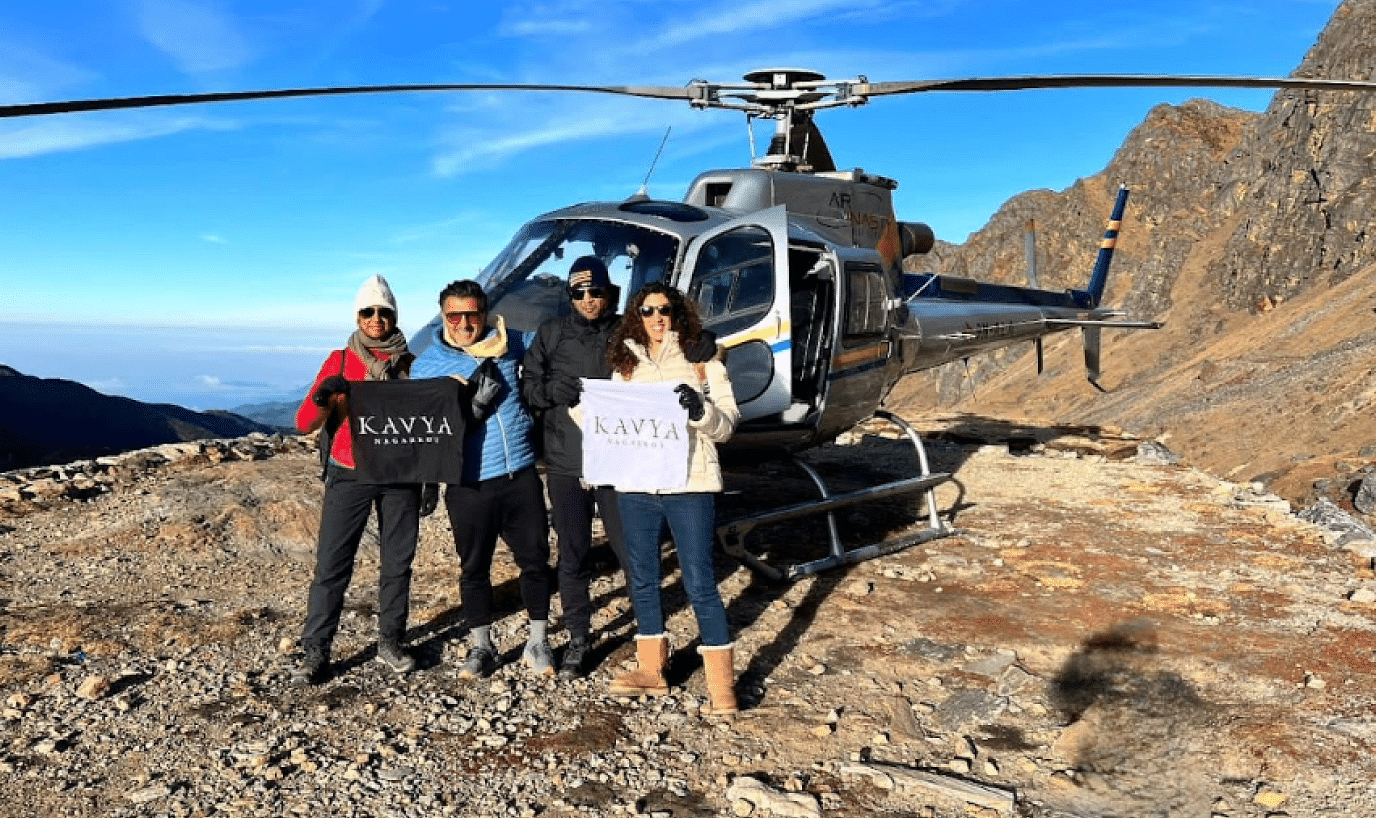 A group of people posing in front of a parked helicopter at the hill | Kavya Resort and Spa, Nagarkot