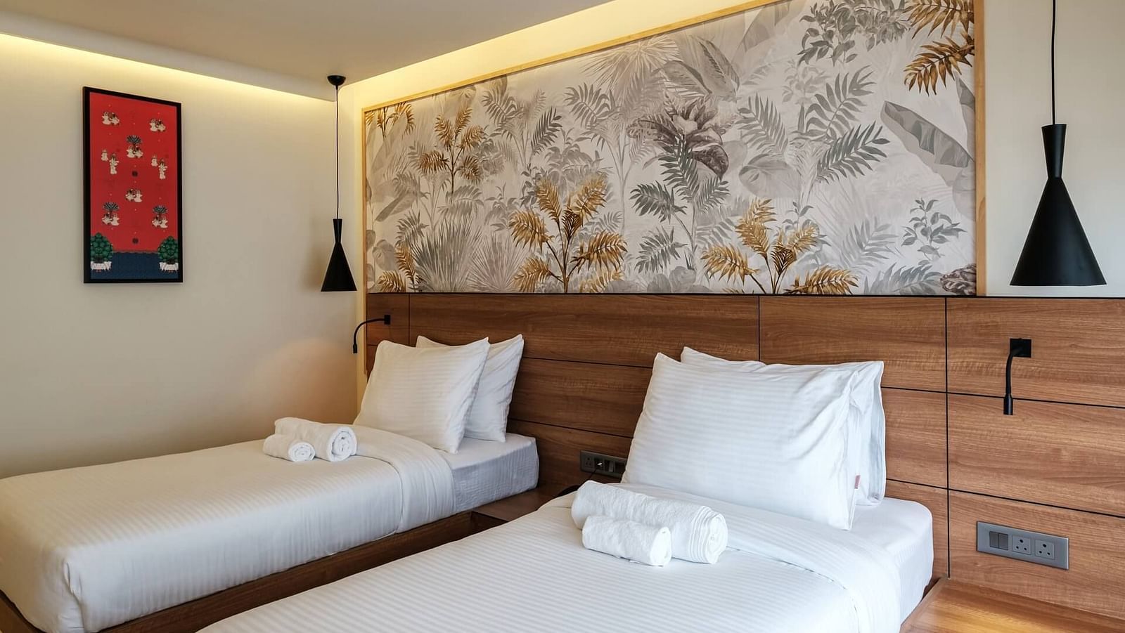 A spacious room at Indie Stays, Jaipur, with two beds and a joined wooden headboard.