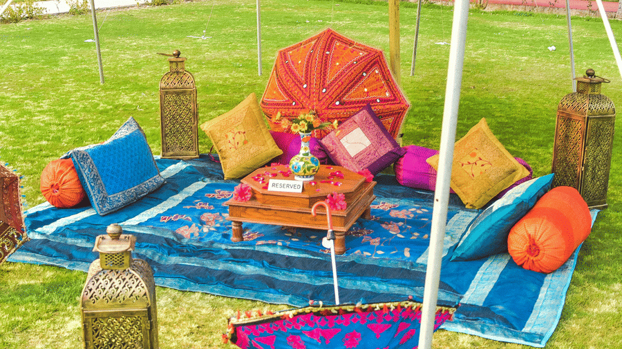 Colourful haldi or mehendi setup with vibrant cushions and décor at Umaid Palace lawn.
