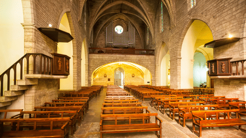 Interior of an old church with wooden benches and stone walls visited during a local tour from Heritage Village Resorts & Spa, Goa.