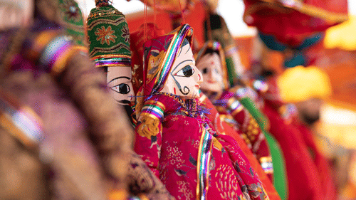 dolls hanging from a rope at a shop