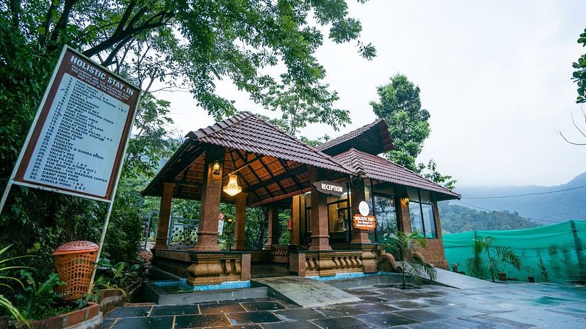 Facade view of the reception with greenery in the background - Holistic Stay Eco Resort, Kannur