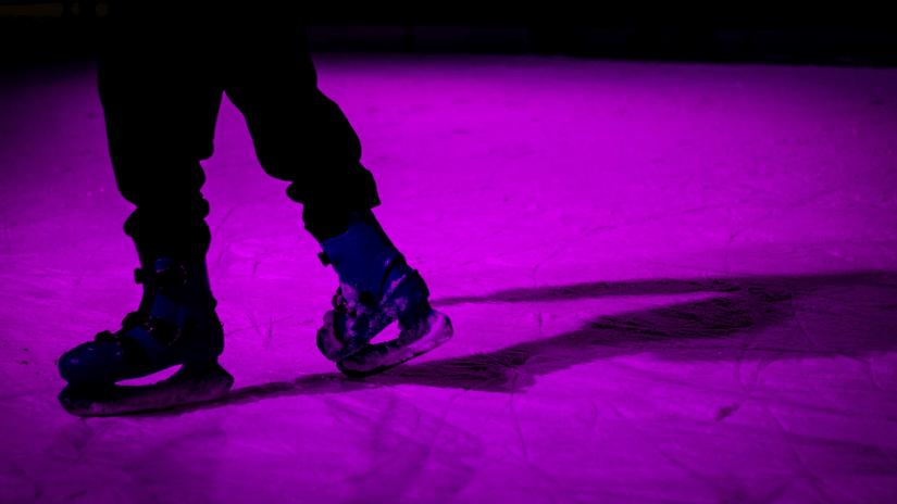 A close up shot of a person on an ice rink while wearing skating shoes