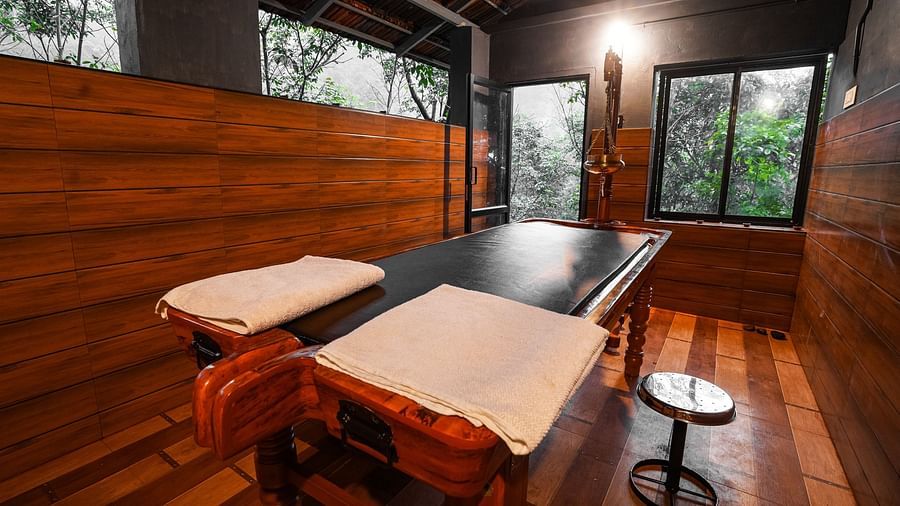 a wooden massage table inside the ayurvedic centre - Holistic Stay Eco Resort, Kannur