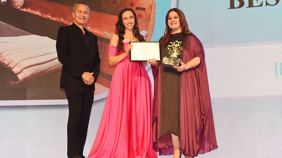 Kiran Bawa receiving an award by a man and a woman - IOSIS Spa & Wellness