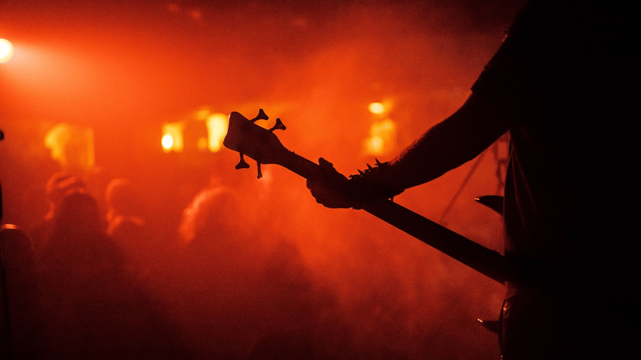 A view from the stage of a artist performing a concert in Doha for a crowd with red light covering the entire place.