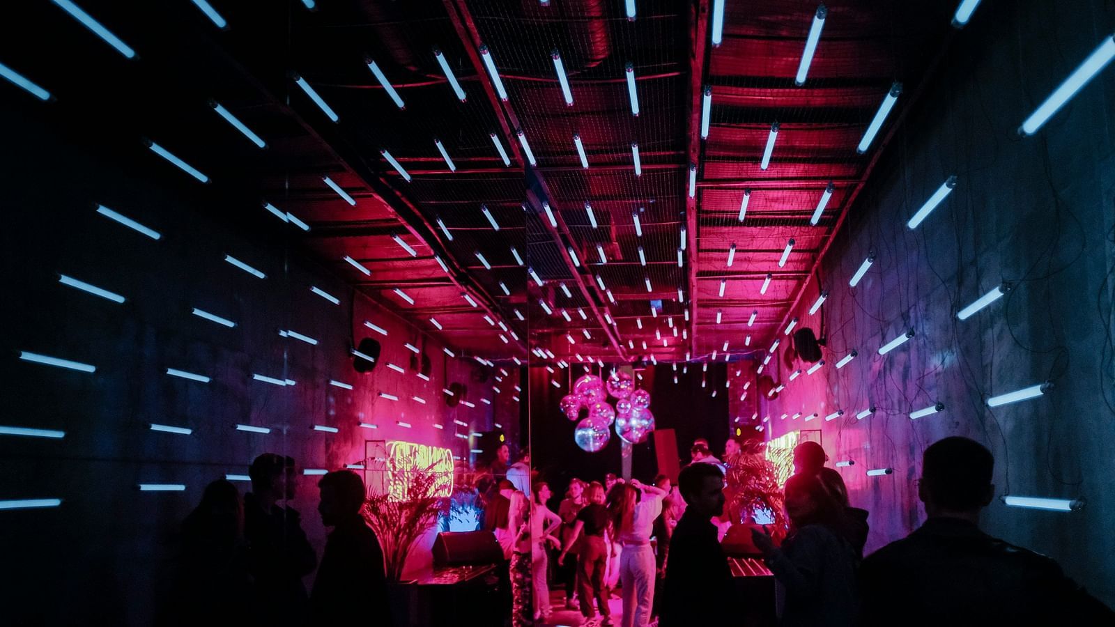 An entrance of a night club with people standing and waiting
