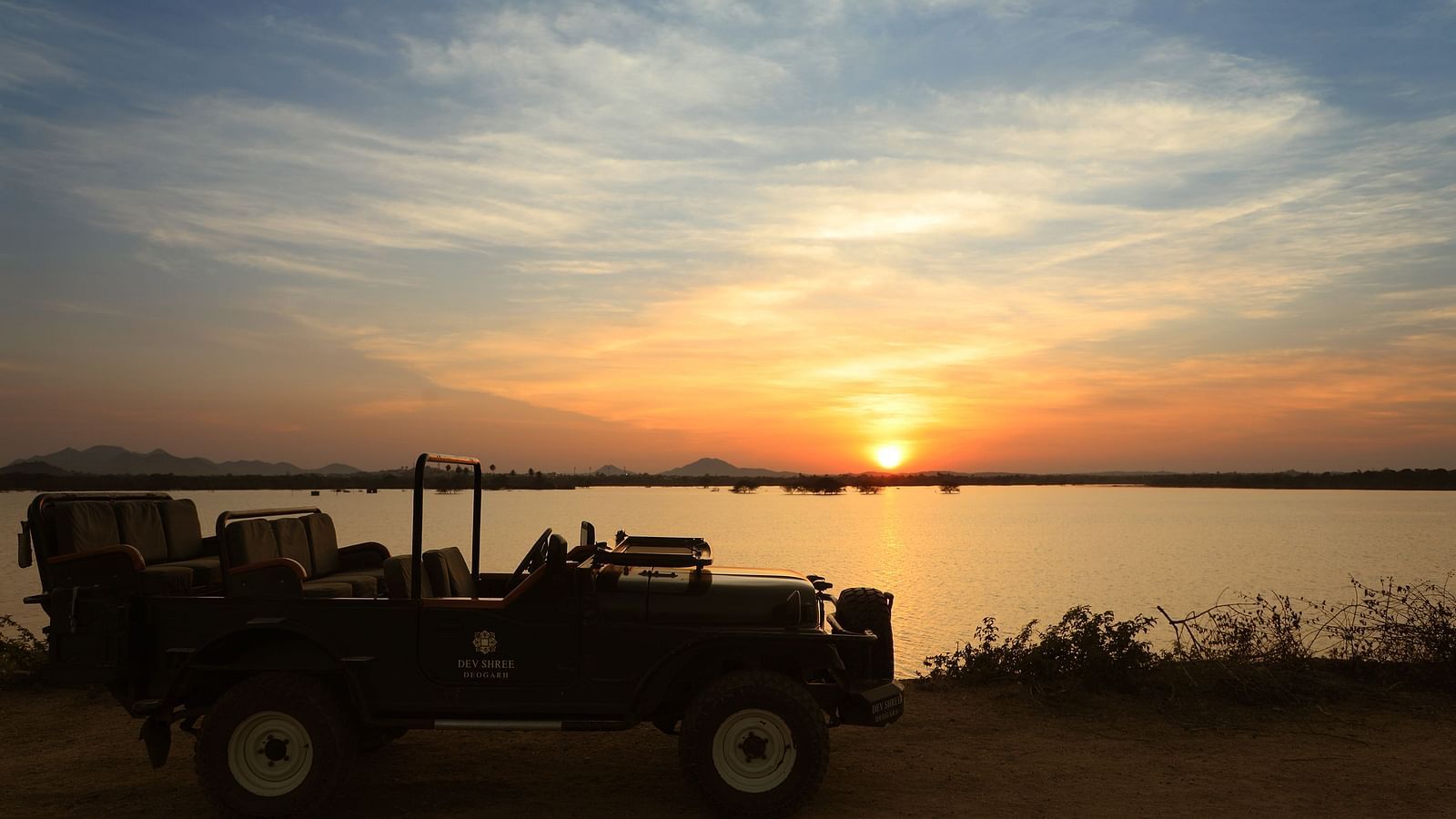 an image of a jeep with sunset in the background at dev shree, deogarh
