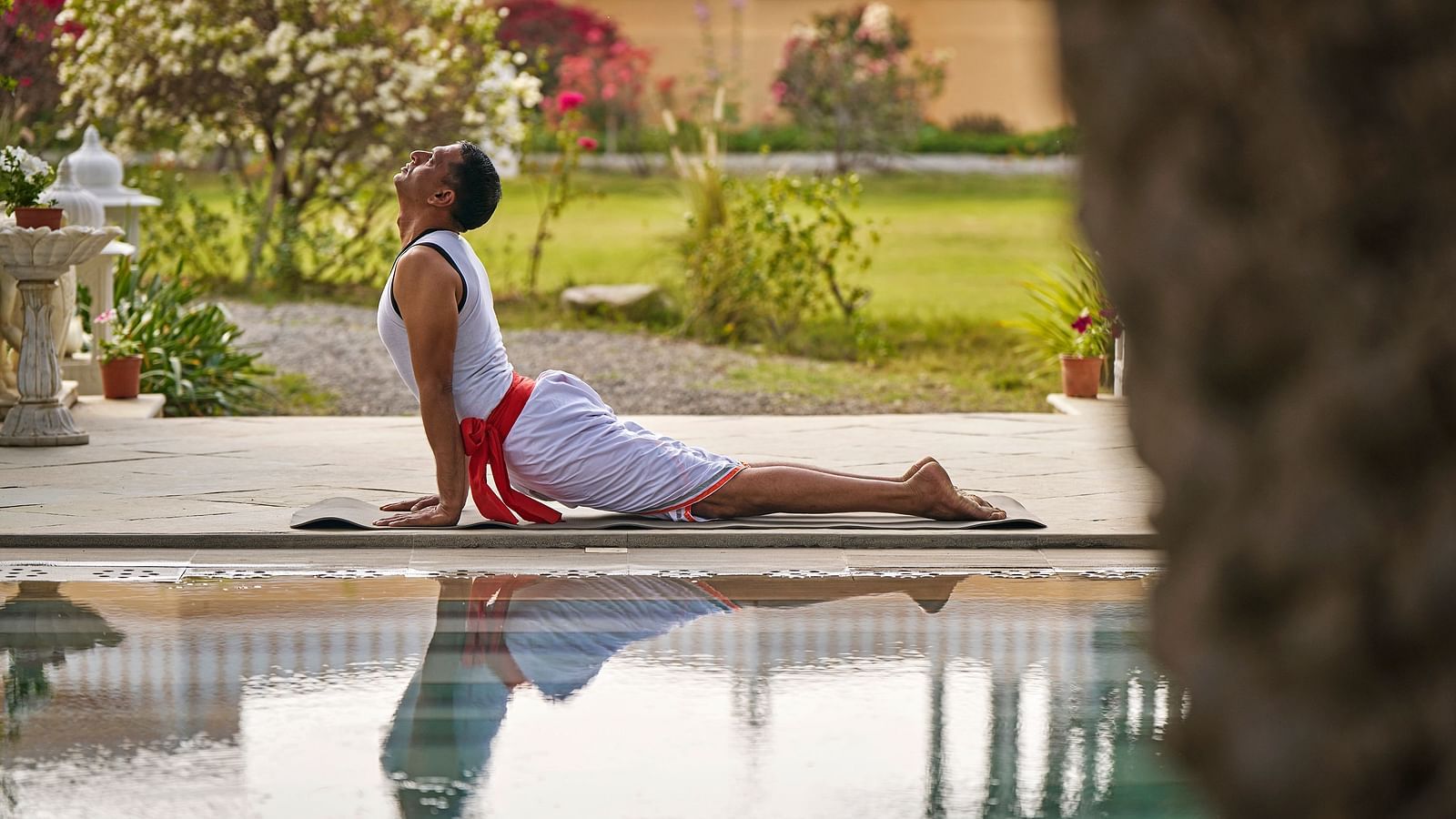 image of a man doing yoga at the poolside at dev shree, deogarh