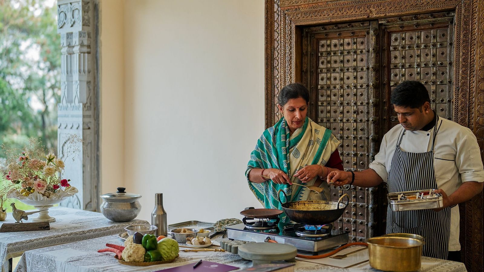 an image of a woman taking culinary classes at Dev Shree, Deogarh along with a trained chef