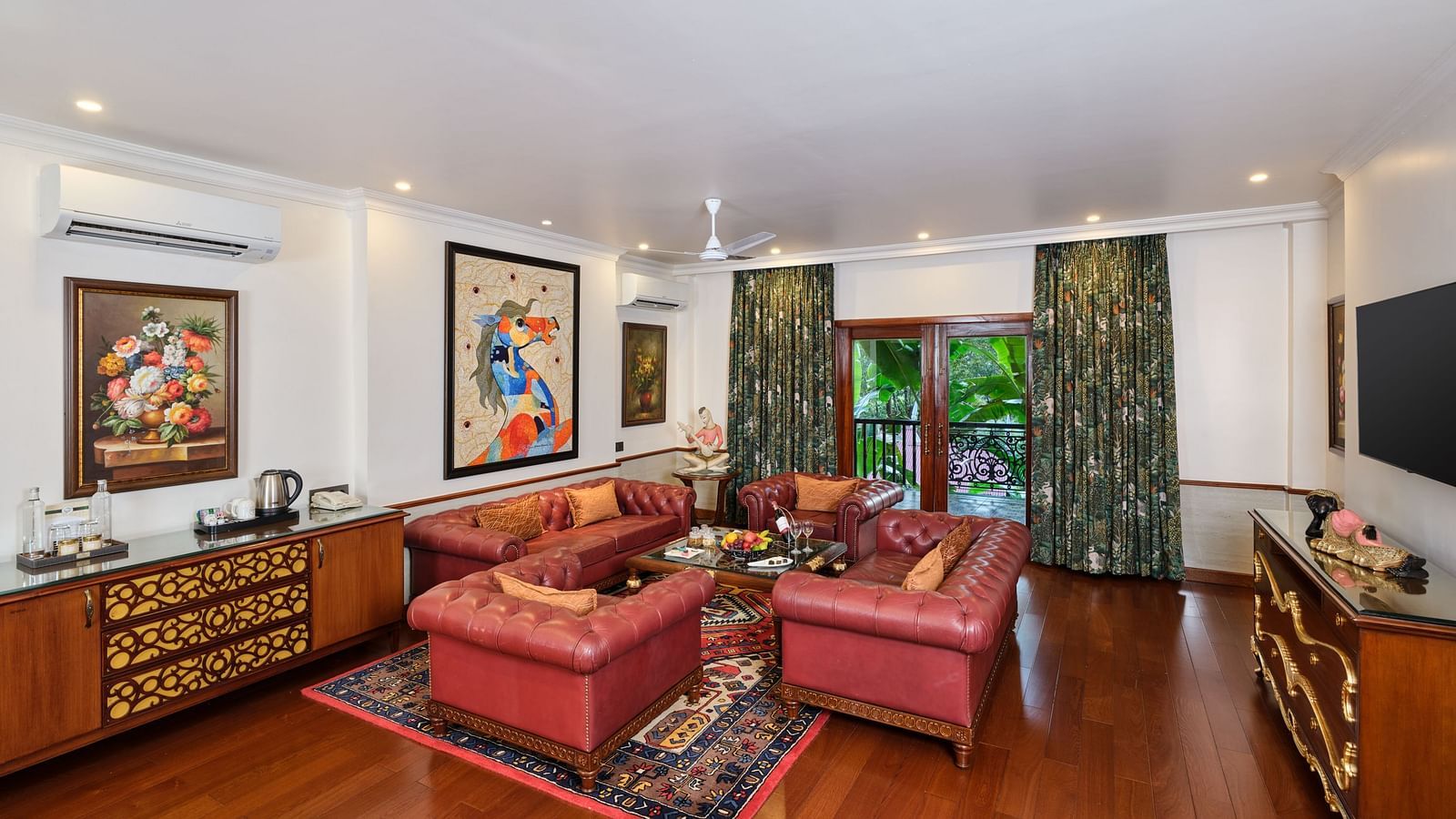 Luxurious Grand Villa lounge with a table, sofa, cupboards, TV,  wall decor, and curtained window with a view at Mayfair spa  resort and casino.