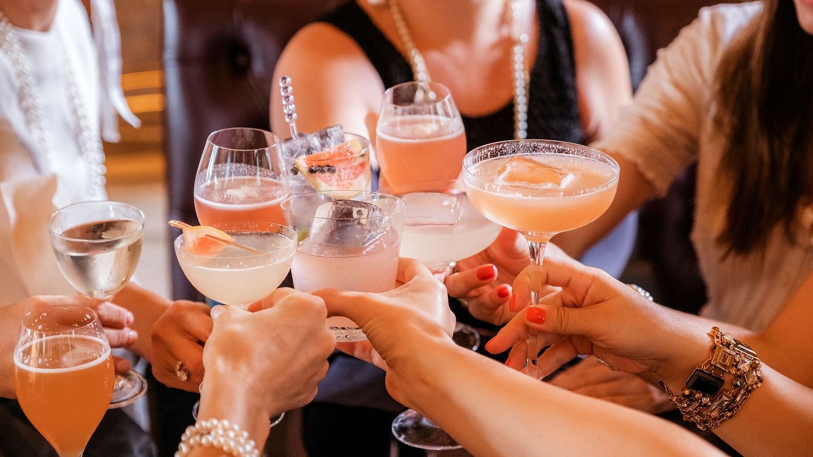a group of people clinking their glasses together during a party
