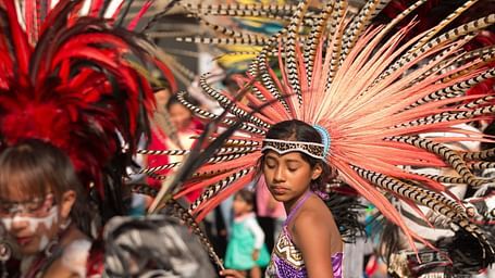 People wearing flashy costumes and dancing at a carnival.