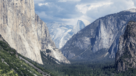 A valley at Yosemite National Park with snow-capped mountains in view.