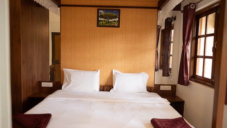 Image of a bed with a frame above it and windows on the side at 2 bhk Studio Apartment, Vistar Holidays, Goa.