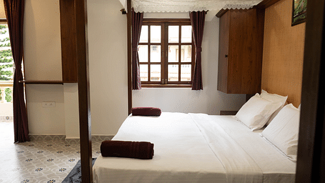 Image of a room with a bed and window on the side at Vistar Holidays, Goa.