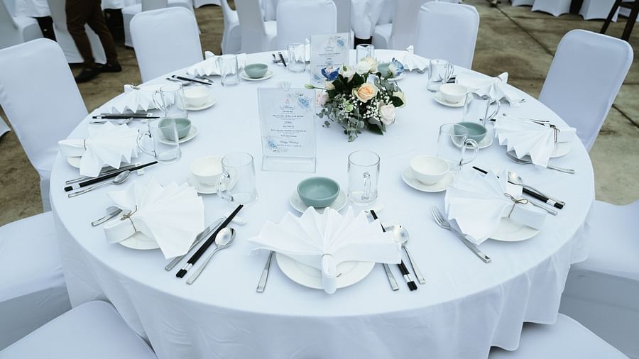 A picture of a table where plates, hand towels, and cutlery is placed - Alibu Resort Nha Trang