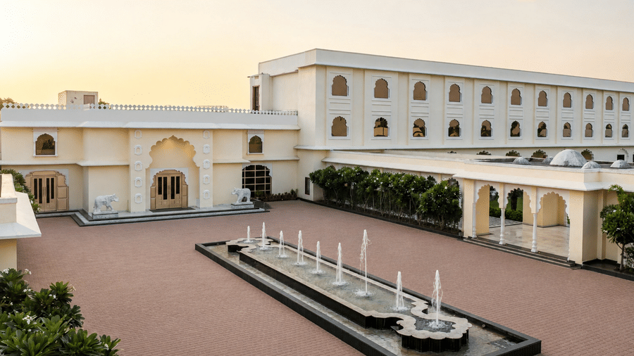 Heritage facade with fountain courtyard at Beelwa Palace, Jaipur at dusk.