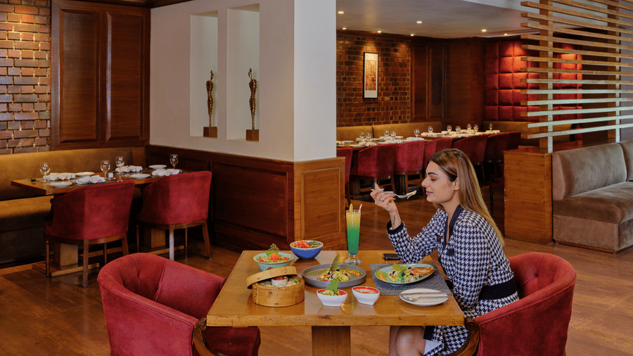 The image appears to be of a woman dining at the Best Western Country Woods restaurant in Ambala.