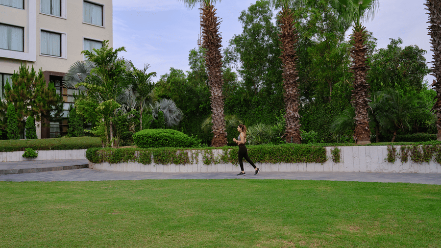 Image of a lady jogging around the lawn at the hotel.