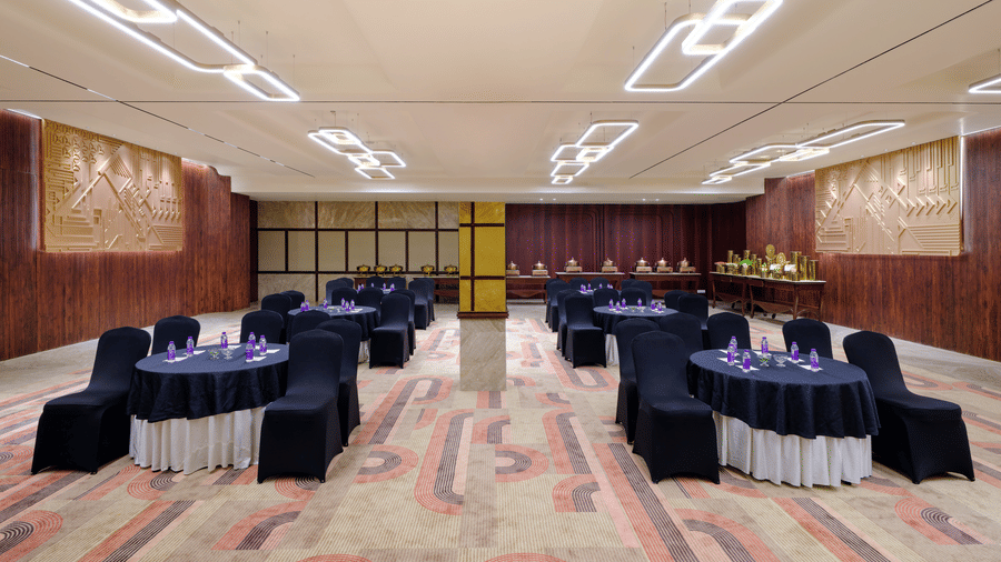 A large, elegant banquet hall with round tables and chairs set up for a formal event  | Best Western Country Woods Hotels and Resorts