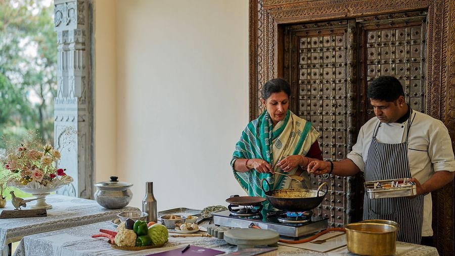 image featuring a woman cooking along with a chef supervising at dev shree deogarh
