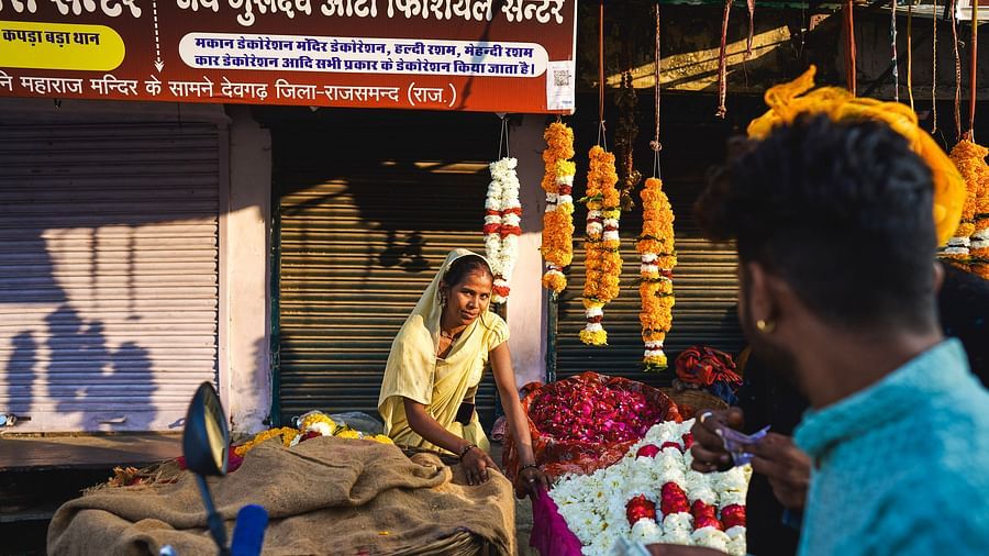 image featuring a woman flower vendor selling various flowers and garlands in a market
