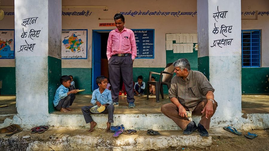 image of the old man sitting on the steps of the school with the children