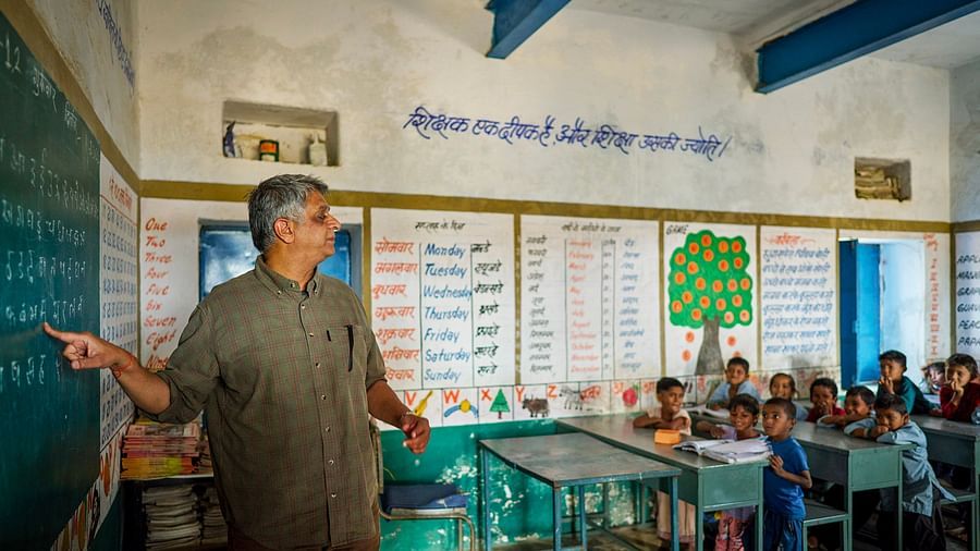 image of an old man teaching with the help of a chalk and blackboard to the students