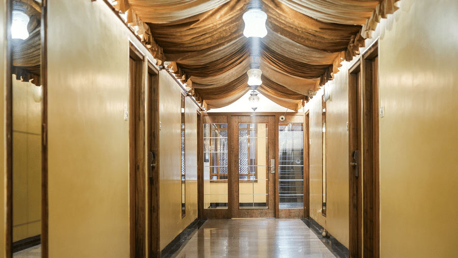 Decorated corridor with marble flooring, fabric draped ceiling, and lights at Infiniti Hotel, Indore.