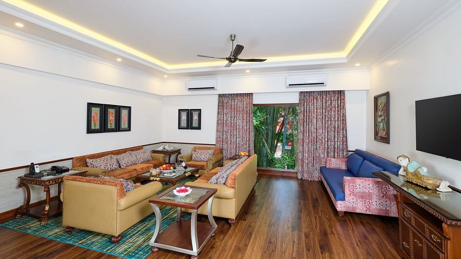 Crown Villa lobby with sofas, table, wooden cabinet, artworks on white walls and a TV