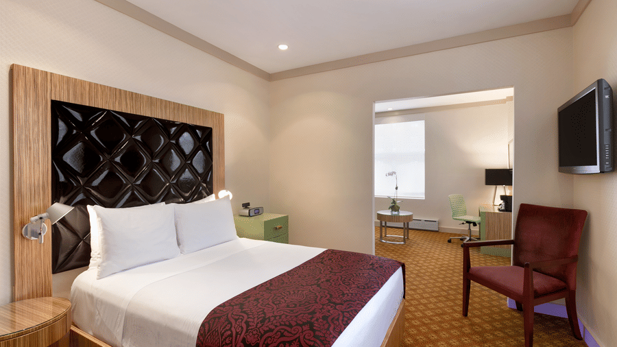 A suite with a comfortable bed, chair and television