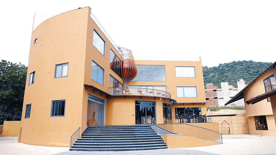The Qualia Resort Club & Brewery, Udaipur showcases a unique architectural design with curved walls and geometric shapes.