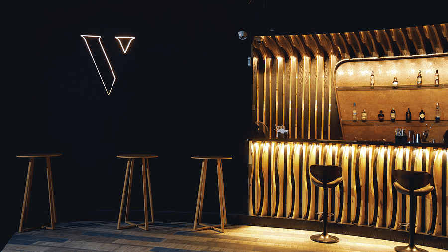 Verve featuring a minimalist logo, warm lighting, and sleek wooden bar stools at The Qualia Resort Club & Brewery, Udaipur.