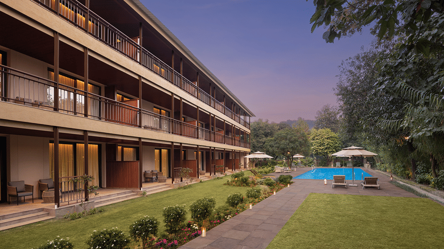 Resort building overlooking a swimming pool and landscaped lawn at The Riverview Retreat, Corbett.