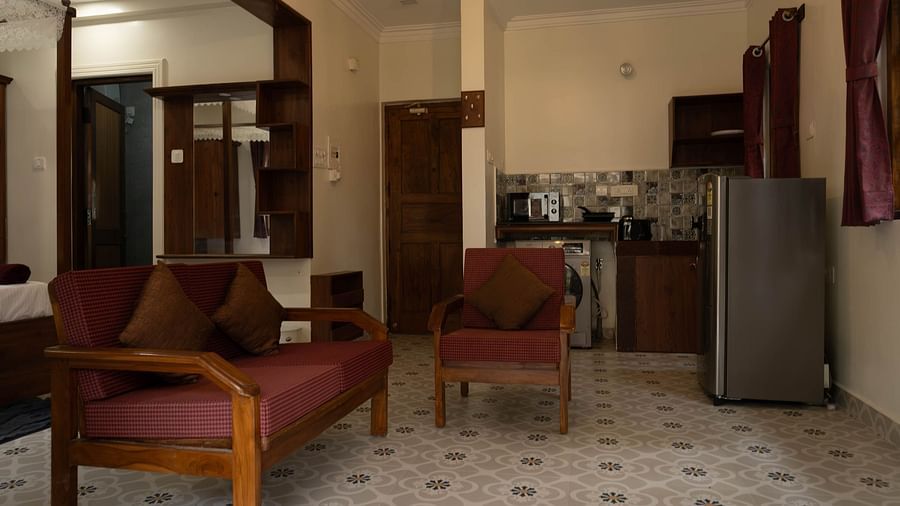 Image of a seating area with sofas and fridge behind at 1 bhk Executive Studio Apartment, Vistar Holidays, Goa.