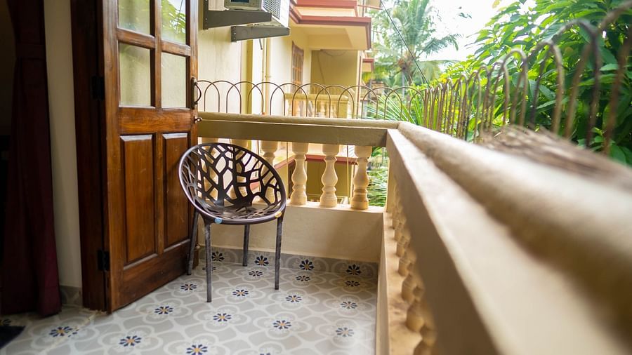 Image of a balcony with a chair and plants nearby 2 bhk Studio Apartment, Vistar Holidays, Goa.