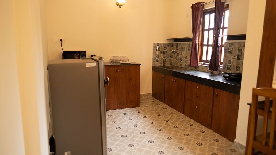 Image of a kitchen area with fridge and cupboards at 2 bhk Studio Apartment, Vistar Holidays, Goa.