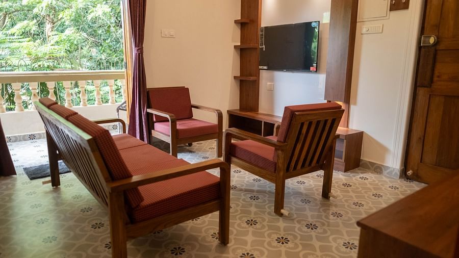 Image of a seating area with sofas and a television mounted on the wall at Vistar, Holidays Goa.