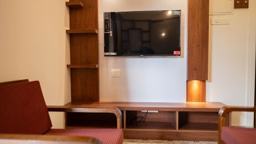 Image of a television mounted on the wall and seating area in front of it at Vistar, Holidays Goa.
