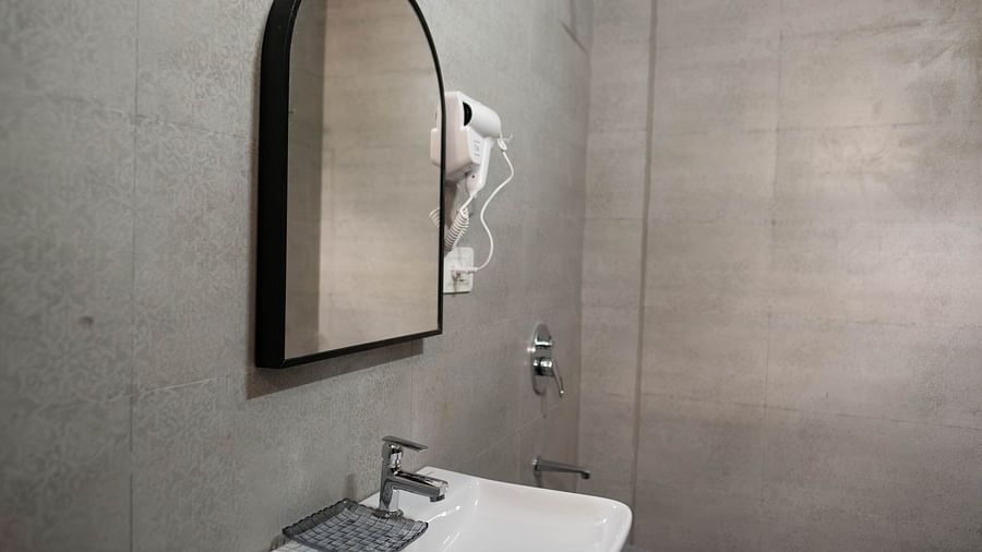 Image of a sink and a glass mounted on the wall at the 1 bhk Executive Studio Apartment, Vistar Holidays, Goa.