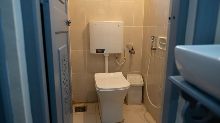 Image of a washroom with a toilet and wastebin on the side at 1 bhk Deluxe Studio Apartment, Vistar Holidays, Goa.